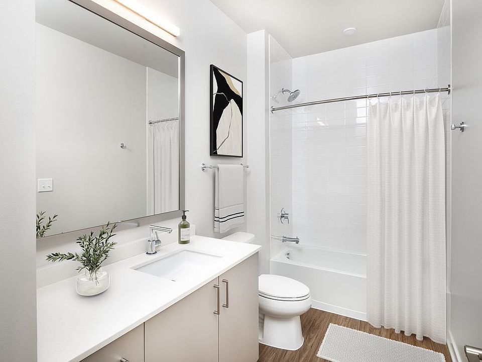 Upgrade Collection I bath with white quartz countertop, light oak cabinetry, and hard surface flooring (representative imagery)