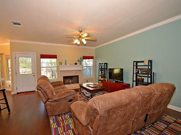 Gorgeous wood floors, a cozy fireplace, crown molding and contemporary color schemes enhance this lovely family room.