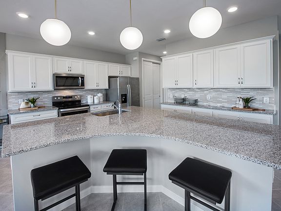 Kitchen with large center island, granite countertops, Moen R faucet, and customizable designer fin
