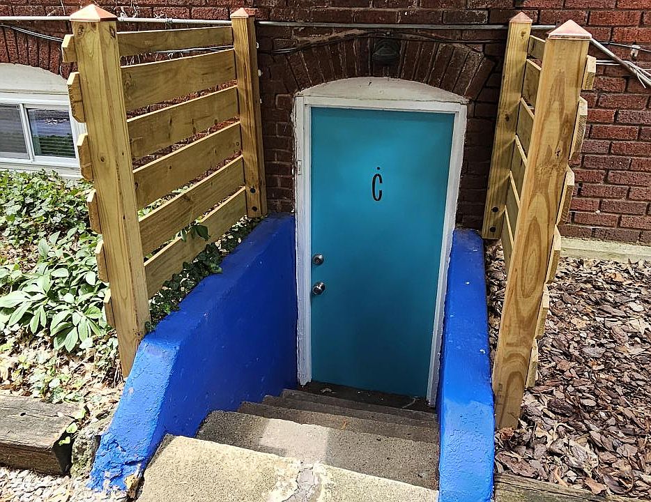 Apartment covered and lit entry off driveway side of building.