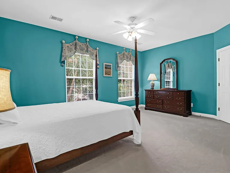 Large primary suite with cooling accent paint and plenty of sunlight. 5' x 6' walk-in closet in the corner, plus another coat closet.