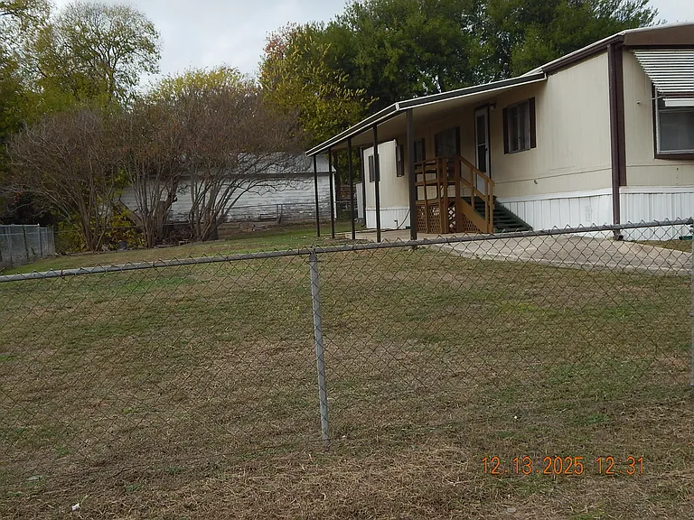 Looking from front of home - shows south side of home large yard and patio cover over front deck.