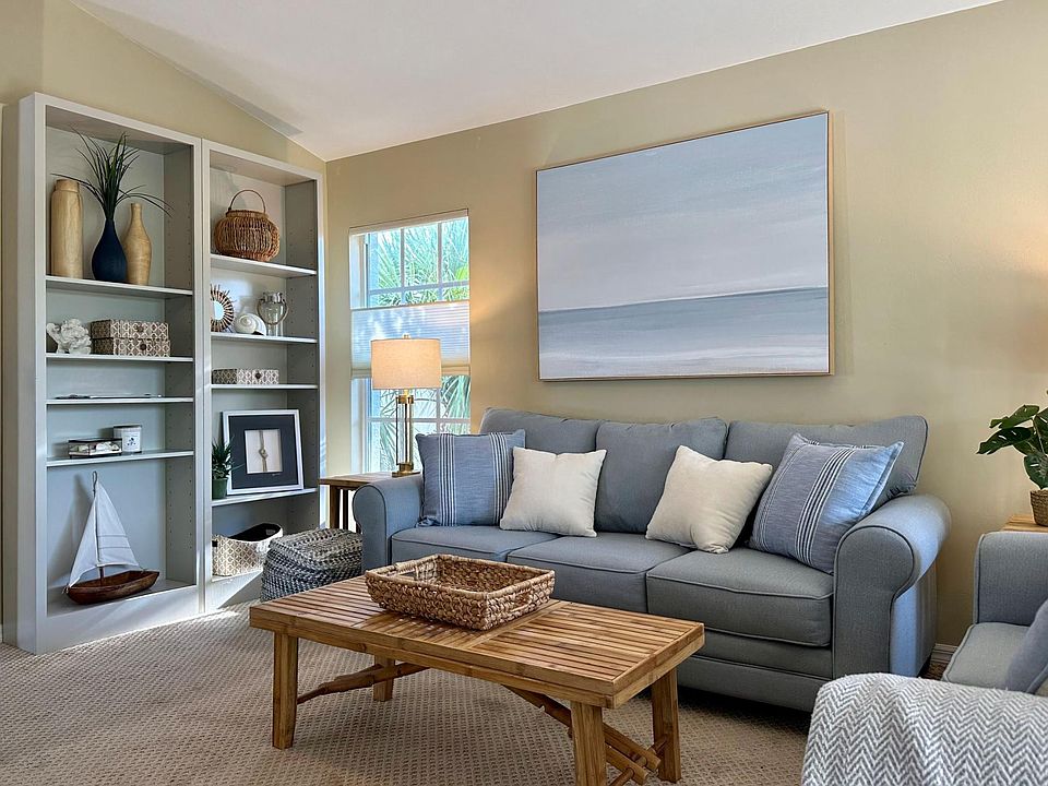 Corner top unit with vaulted ceilings, additional windows for natural light, ceiling fan, sleeper sofa, loveseat, TV and built in bookshelves.