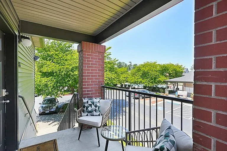 Relax and enjoy your personal outdoor haven with this charming balcony overlooking a lively neighborhood.