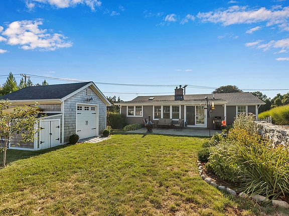 The  back of the home features a stamped concrete patio, 12 x16 shed, low maintenance landscaping and a stone wall bordering the 14th green of Shennecossett Golf Course.