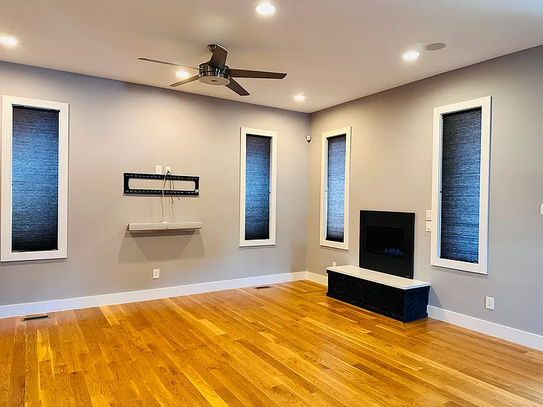 A view of the den with hardware already installed and waiting for your T.V. Notice the fireplace on the right side! By the way, there are blinds in every window of the home.