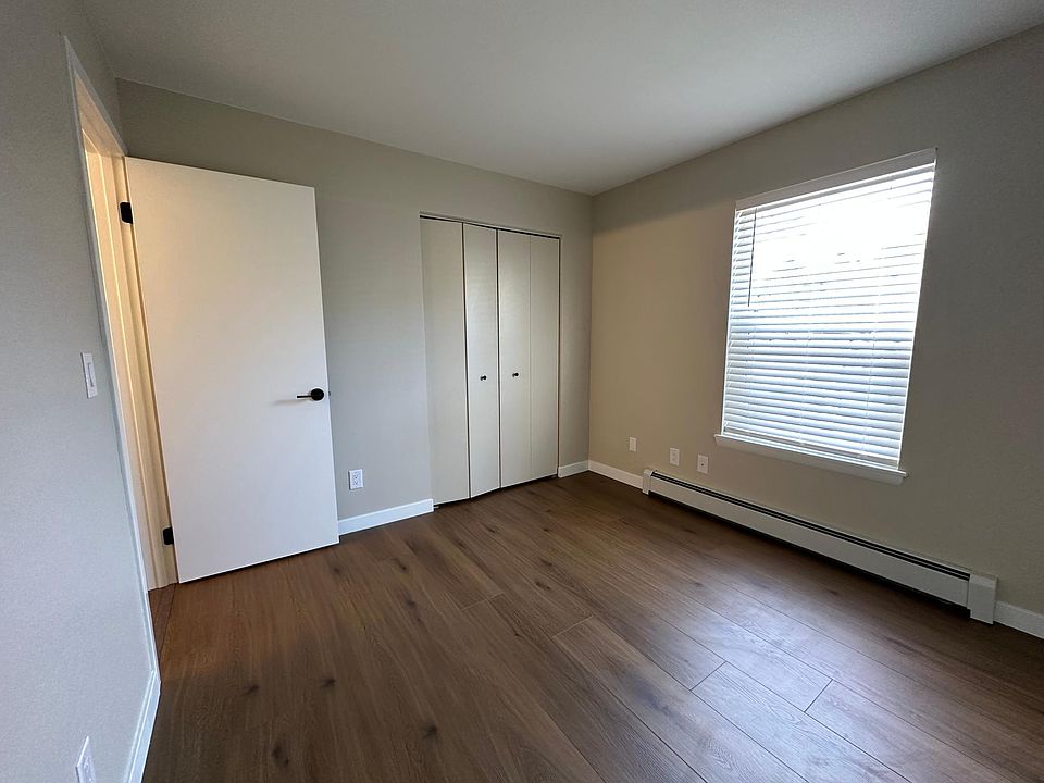 Bedroom with new flooring, fresh paint, new blinds, and two storage closets