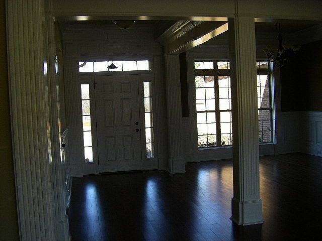 Foyer with wood floors and extensive molding welcomes guests and family