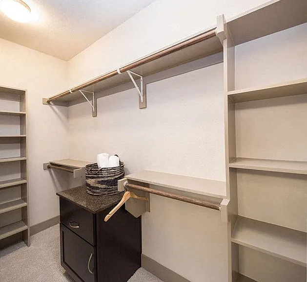 Walk-in closets with custom shelving and pass-through hampers