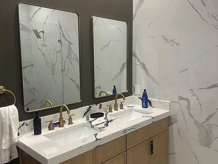 Updated bath with double-sink vanity, generous storage, and elegant tile finishes paired with contemporary fixtures.