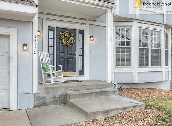 Charming front porch with freshly painted front door.