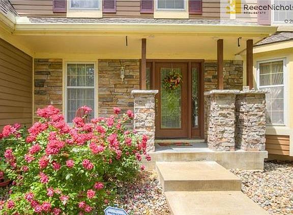 New stacked stone pillars and front door.  Inviting front porch!