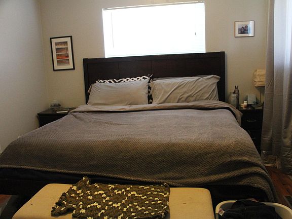 King sized bed is pictured, an end table on each side with room to spare, and 4.5 feet from the end of the bed to the wall.