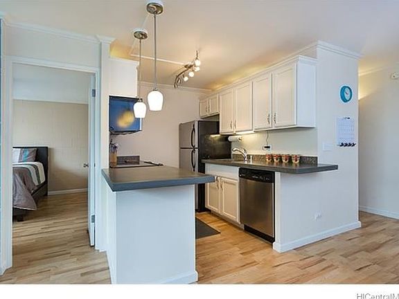 Clean and open kitchen with stainless appliances and recessed lighting.