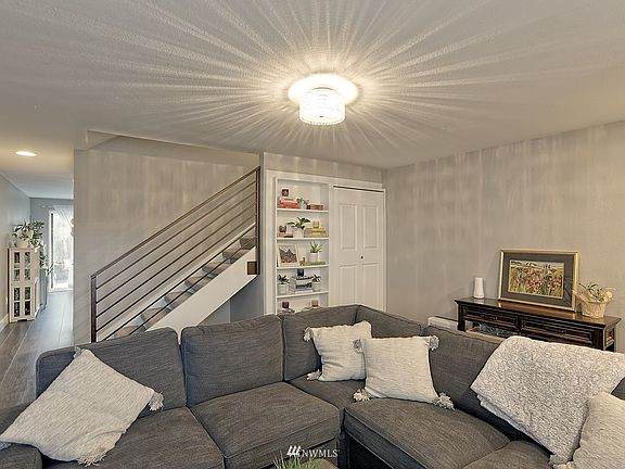 Living Room with Designer Lighting Fixture and A Custom Built In Shelf for Books and Decor.