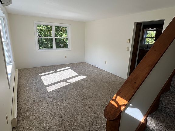 View from front entrance into living room and stairs to second floor