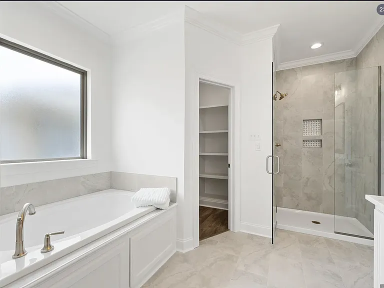 a separate glass-enclosed shower, and dual walk-in closets for ample storage and convenience.