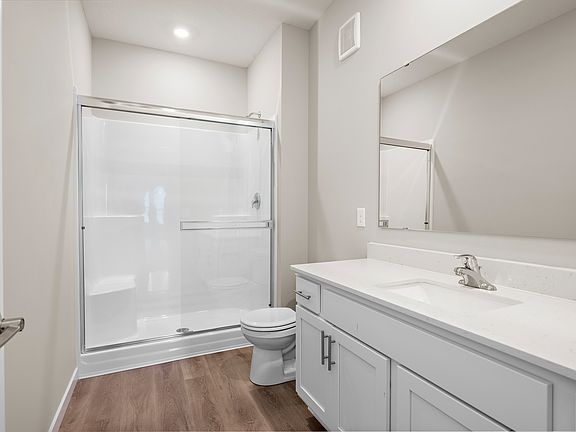 The master bathroom has a large vanity and a step in shower.