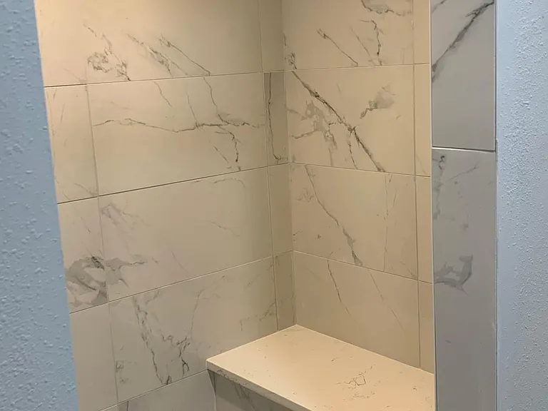 Lower level tiled shower. Bench seat area