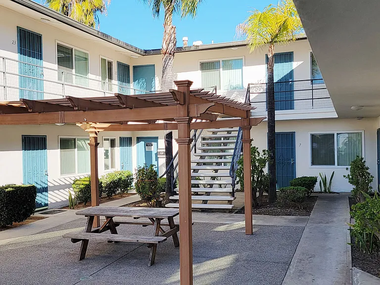 Picnic table undre pergola in courtyard perfect for lunch or dinner at Orlando Woods Apartments in El Cajon, California.
