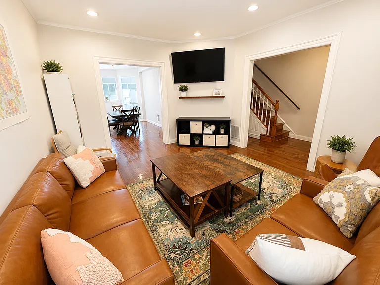 The living room looking towards the dining room and kitchen. The sofas, coffee table, rug, tv, and dining table are only about a year old and provided for communal use.
