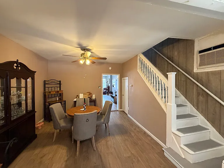 Looking from kitchen back to dining area and staircase to 2nd floor