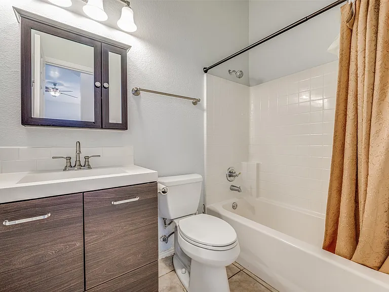 Guest bath Contemporary bathroom featuring a dark wood-finish vanity with an integrated sink, brushed nickel faucet, and matching medicine cabinet