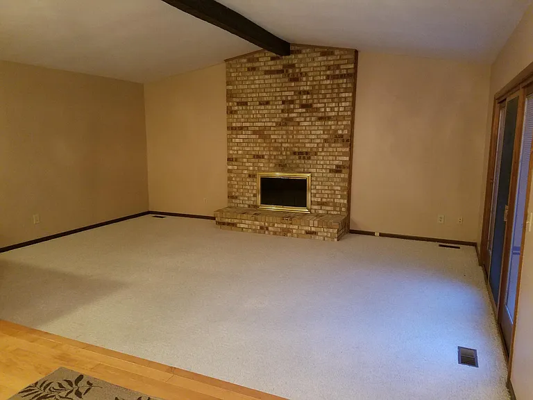 Back Living room with wood burning Fireplace.