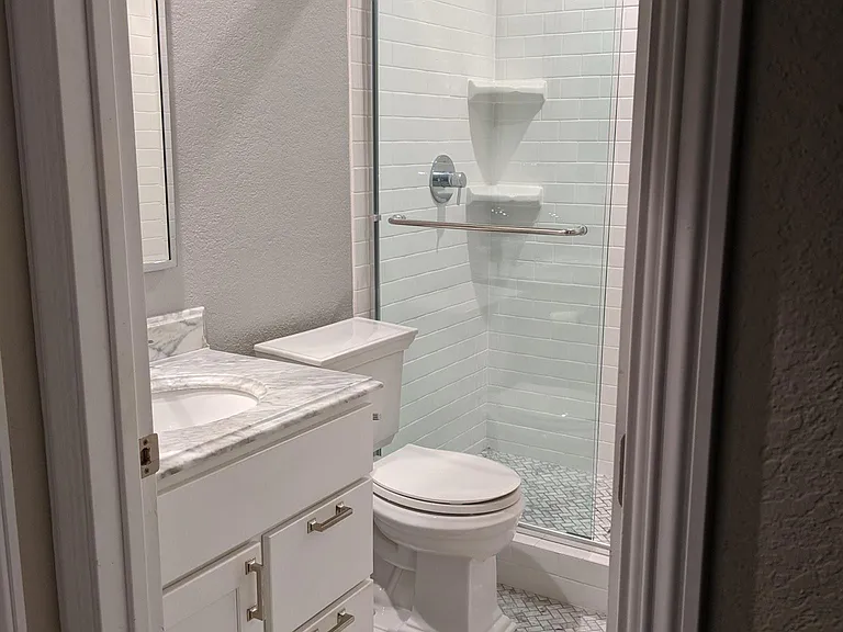 Master bathroom. Fan separate from lighting, ultra quiet fan, marble countertops and flooring throughout. White subway tile with ledge inserts. Upgraded water efficient toilets.