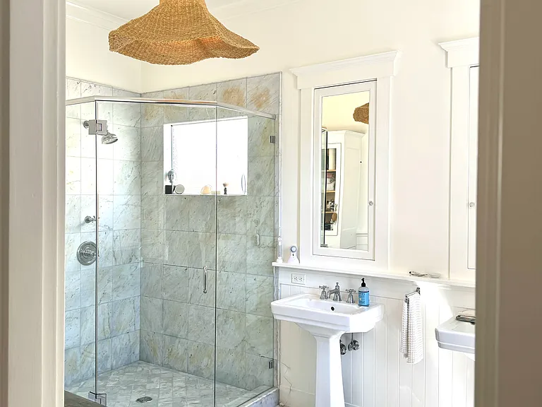 Primary bath with two pedestal sinks and large walk-in shower
