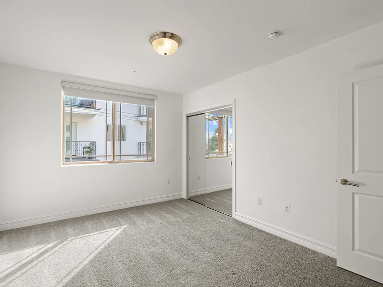 Bedroom with Window and Mirrored Closet
