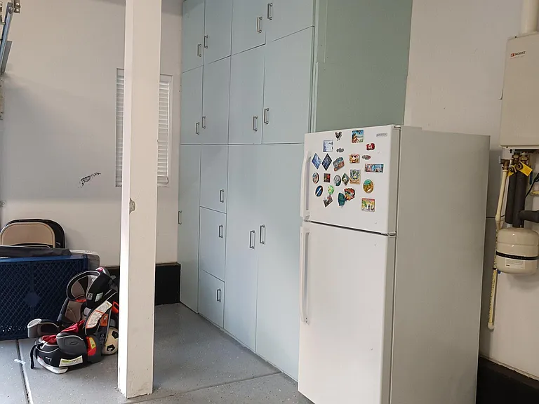 This picture showcases the spacious cabinets with a depth of 32 inches, perfect for storing all your tools and equipment. With a height of 12 feet and a width of 10 feet, this garage offers ample storage space while still accommodating 2 and a half cars.
