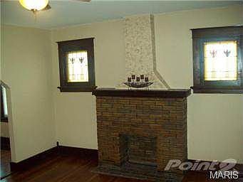 Fireplace in living room flanked by stained glass windows