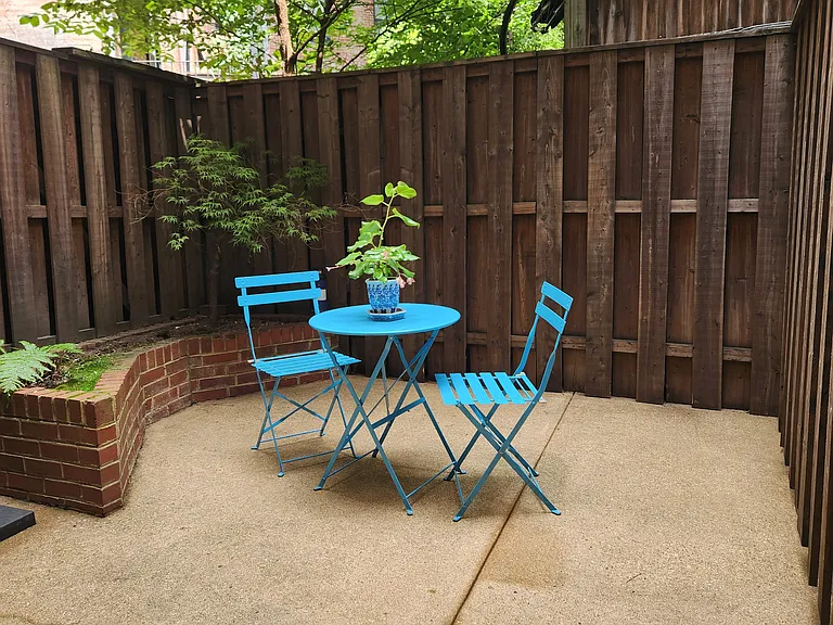Serene patio equipped with charcoal grill and sitting area.