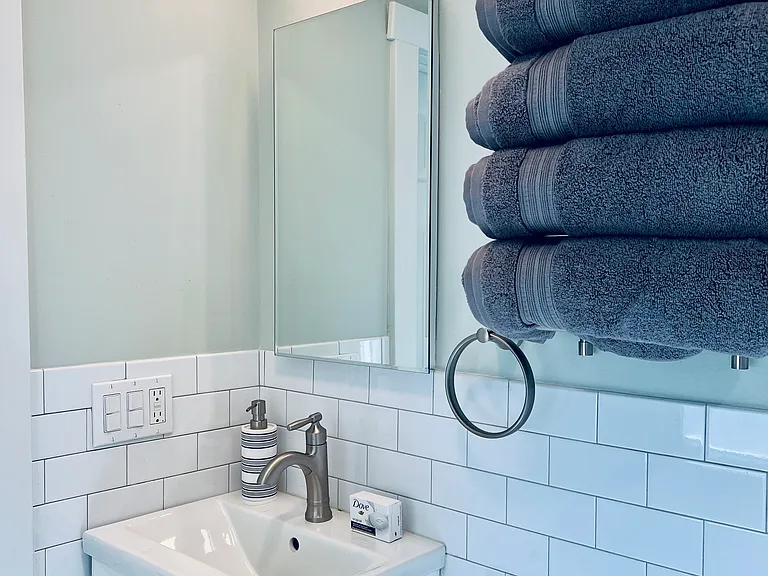 Private bath with floating sink, storage and shower.