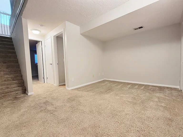 Large rec room in basement. Looking to bathroom and basement bedroom at the end of the hall. Note: Large closet between the bathroom and bedroom