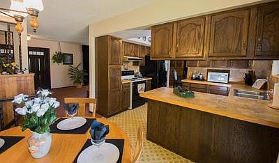 View of kitchen eating nook and kitchen and front door from the sliding glass do