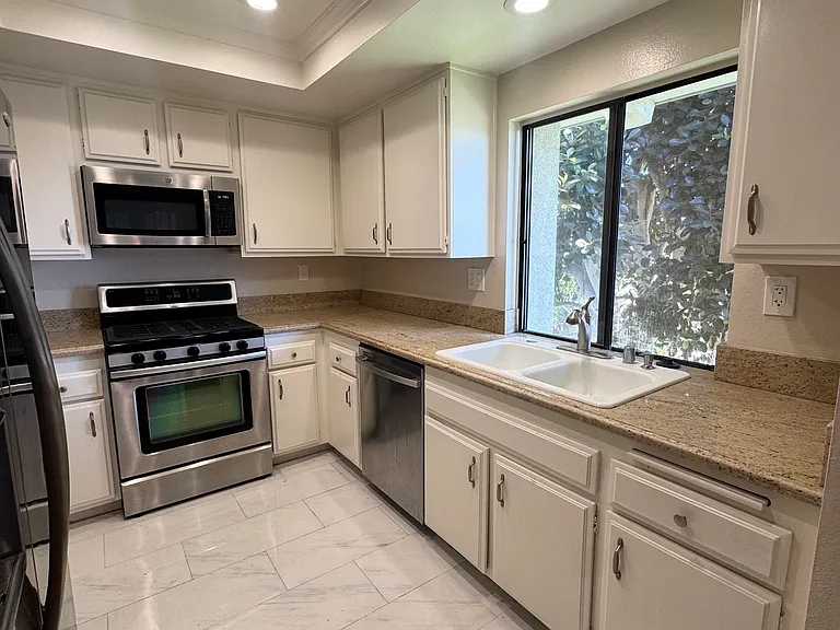 Kitchen with white cabinets, beautiful granite countertops, stainless steel appliances, gas stovetop