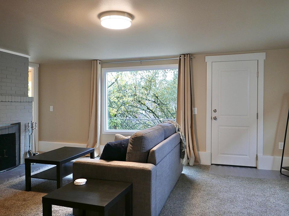 Living room and front door entrance. The apartment is fully furnished with a working fireplace and blackout curtains.