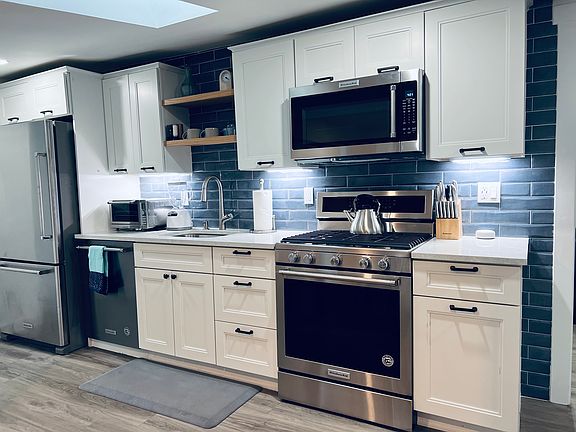 Chef's eat-in kitchen with quartz countertops and Kitchen Aid appliances. Fully equipped, pantry stocked with pots, pans, skillets.