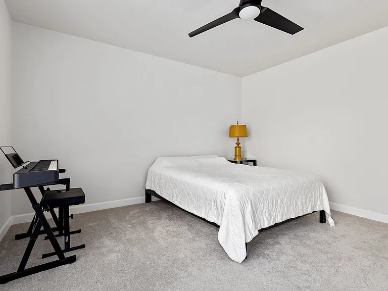 Carpeted bedroom with ceiling fan