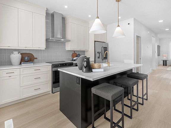 This modern kitchen features full-height cabinets, providing ample storage for all your culinary nee
