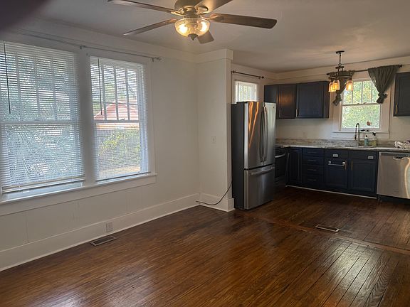 Standing in the living room Looking into Dining room then kitchen. To the right is a little hallway with the bathroom in center and a bedroom to left and right.