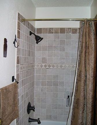 Bathroom with travertine tilework and bronze fittings