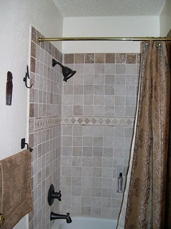 Bathroom with travertine tilework and bronze fittings
