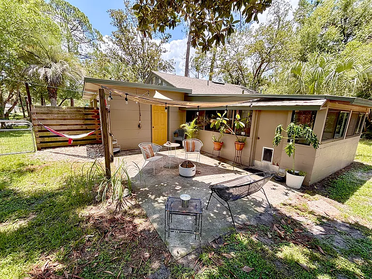 Back patio off Florida room for entertaining and closed in storage connected to carport