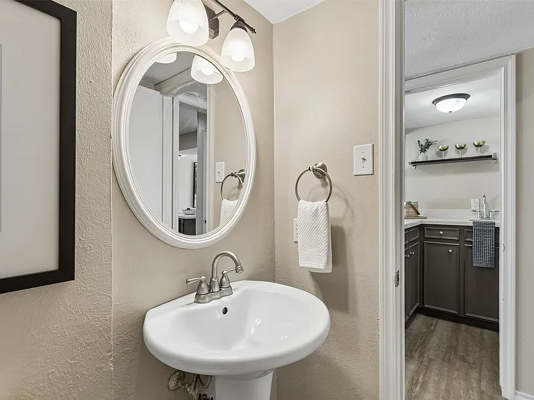 The powder bath features a pedestal sink and easy access to the living and kitchen areas.