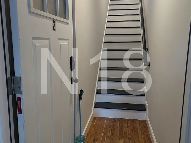 Unit entrance with stairs leading to the main floor