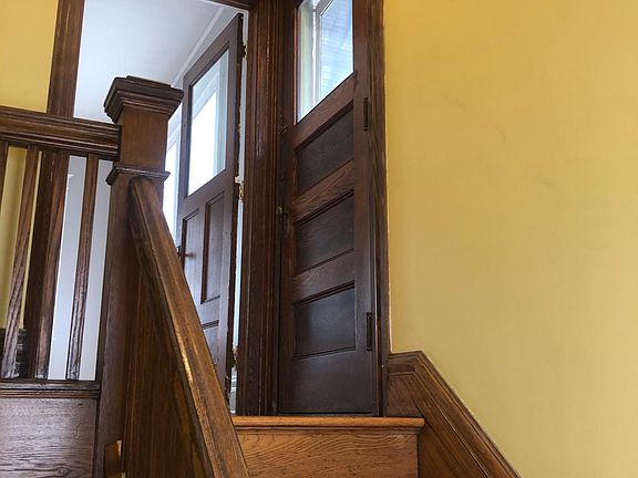 Side entrance stairway foyer. Door on right is entrance to upper private porch.