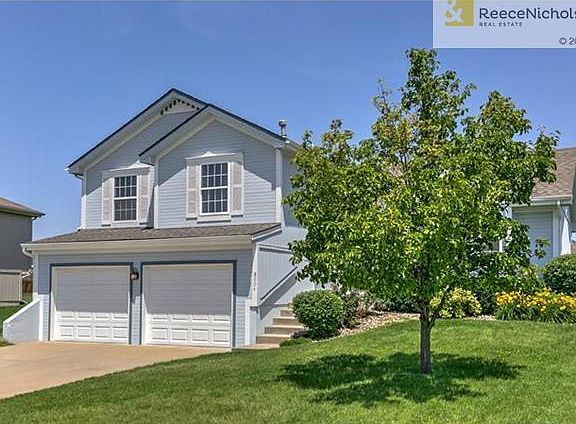 Manicured lawn and lush landscaping add to the curb appeal.